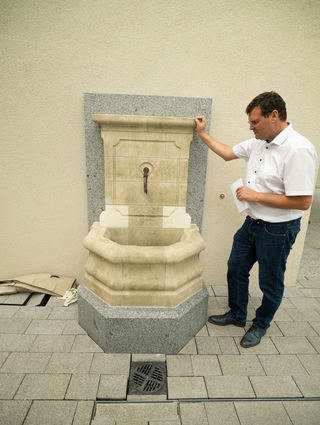 Bürgermeister Nils Drescher zeigt den neuen Trinkwasserbrunnen vor dem Bürger-büro. Nur einige kleinere Arbeiten stehen hier noch aus.
