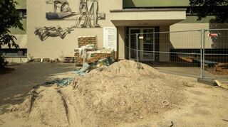 Das Lehrschwimmbecken befindet sich direkt neben der Friedrichschule. Schon vor dem Gebäude reiht sich das Baumaterial an der Mauer.