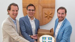 Bundestagsabgeordneter Olav Gutting (l.) und Landtagsabgeordneter Andreas Sturm (r.) überreichen Bürgermeister Kevin Weirether eine Vier-Sterne-Torte.