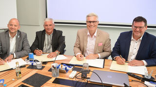 Pascal Seidel, Bürgermeister von Oftersheim (v. l.), Kozolets Bürgermeister Valentyn Bryhynets, Schwetzingens Bürgermeister Matthias Steffan und das Verwaltungsoberhaupt der Gemeinde Plankstadt Nils Drescher unterzeichnen die mehrfach ausgedruckte Solidaritätsvereinbarung.