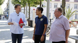 SWR-Moderator Jens Hübschen (v. l.) , TV-1864-Vorsitzender Athi Sananikone und Sportredakteur Andreas Lin von der Schwetzinger Zeitung bei der Schnellraterunde auf dem Schlossplatz.
