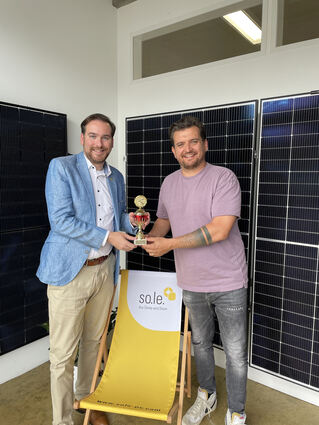 Andreas Sturm (l.) mit Marcel Lehmayer und dem Pokal, den das Unternehmen als bester Solaranbieter im Land erhalten hat.