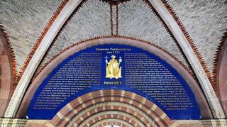 Das ist die Nachbildung der Privilegieninschrift über dem Hauptportal des Doms – sie wurde anlässlich des Salierjahres 2011 angebracht.