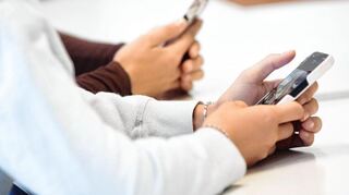 Schülerinnen eines Gymnasiums benutzen während eines Vortrags über Künstliche Intelligenz (KI) ihr Smartphone im Unterricht.