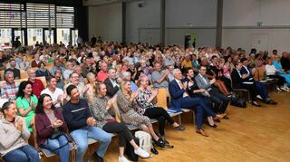Das Foto entsteht direkt zum Auftakt der Veranstaltung im Lutherhaus. Beide Kandidierenden sitzen noch in der ersten Reihe, bevor sie sich präsentieren.