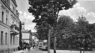 Diese Foto entstand um 1915 und zeigt links im Hintergrund das damals als Postamt genutzte Gebäude. Die Straßenbahn nach Ketsch fuhr bis 1938.