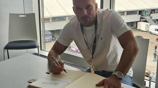 Lukas Podolski trägt sich ins Goldene Buch der Stadt Hockenheim ein.