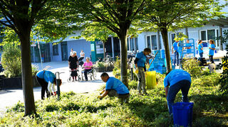 Gartenarbeit bei schönstem Wetter: Die Freiwilligen bringen die Grünanlage und die Pflanzkübel vor dem GRN-Seniorenzentrum in der Bodelschwinghstraße auf Vordermann.