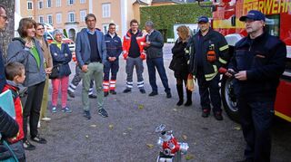 Ralf Innetsberger von der Feuerwehr (r.) erläutert den Gästen – darunter die Geschäftsführerin der Staatlichen Schlösser und Gärten, Patricia Alberth (l.), sowie Staatssekretärin Gisela Splett (3. v. l.) – die Geräte aus dem Feuerwehrfahrzeug.