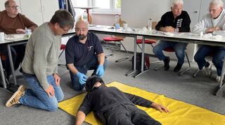 SFC-Mitglied Frank Heyne (l.) bei der Einweisung von DRK- Referent Silvio Popara, der die korrekte Abnahme eines Helmes zeigt.