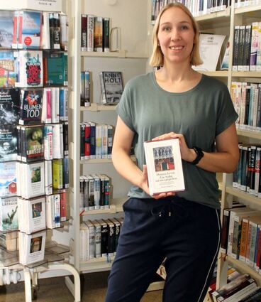 Kriminfan Lisa Westphal leitet von nun an die Gemeindebücherei Oftersheim. In den Händen hält sie ein Buch ihrer Lieblingsautorin Donna Leon.