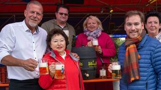 Nach dem Fassbieranstich stoßen OB Marcus Zeitler (li.), HMV-Geschäftsführerin Birgit Rechlin (Mitte) und der Landtagsabgeordnete Andreas Sturm (r.) zusammen mit den Schaustellern an.