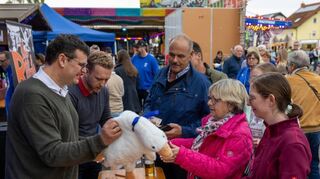Bürgermeister Nils Drescher (l.) beim Verkauf der Kerwegänse, die von den Besuchern gerne als Erinnerung mitgenommen werden. Der Erlös geht an die Notgemeinschaft.
