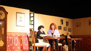 Agathe (Marie-Louise Mott, l.) kann Theatergeist Balduin (Gerhard Hasch, r.) sehen. Chefin Daphne Ballschuh (Giovanna Bracco-Obst) ahnt nichts davon.