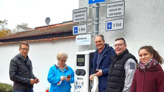 Der Start des Ladesäulenspaziergangs mit Bürgermeister Dr. Ralf Göck (Mitte) sowie dem Kliba-E-Team Bernhard Bruch (l.) und Jessica Skowron (r.) an der Ladestation auf dem Rathaus-Parkplatz.