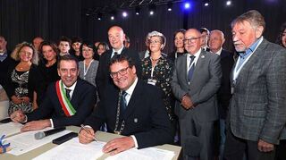 Bei Galaabend unterzeichnen die Rathauschefs der Partnerstädte Andrea Baldini (l.) und Nils Drescher in der Mehrzweckhalle Plankstadt die gemeinsame Partnerschaftsurkunde.