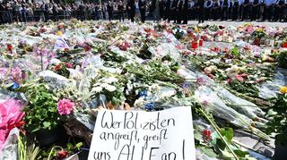Blumen und Kerzen liegen bei einer Gedenkminute auf dem Marktplatz in Mannheim zum Gedenken an einen getöteten Polizisten. Gegen den mutmaßlichen Täter hat die Bundesanwaltschaft nun Anklage erhoben.