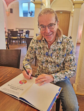 Chako Habekost signiert seine Asterix-Übersetzung "Asterix als Palatinator".  Unter chakosladen.de kann man Chako-Produkte mit persönlicher Widmung bestellen.
