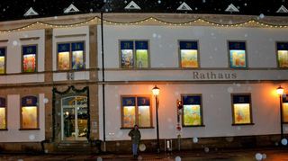 Bisher einmalig: 2017 schneit es, als bereits ein Großteil der Fenster des Plankstadter Rathaus-Adventskalenders und die Eingangs-tür beleuchtet sind. In diesem Jahr feiert der überdimensionale Kalender seinen 20. Geburtstag.