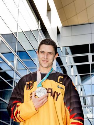 Marcel Goc präsentiert 2018 die olympische Silbermedaille.