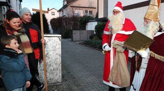 Nikolaus Tobias Kreichgauer (v. r.), Knecht Ruprecht alias Caspar Schatz und Fahrerin Kiara Kembs besuchen Familie Schimmele im Brühler Blumenviertel.