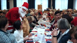 Der Nikolaus alias Julian Thüning verteilt bei der Feier für Altersjubilare der Gemeinde im Publikum kleine Geschenke.