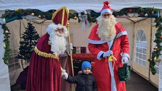 Nikolaus (Dieter Endres) und Knacht Ruprecht (Caspar Schatz) beschenken die Kinder am Tafelladen Appel + Ei“. mit Geschenk-tüten. Auch eine Spende hat die Gruppe wieder angekündigt.