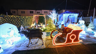 Die Lichter eines Weihnachtshauses, das von einer Privatperson aufwändig hergerichtet wurde, erstrahlen in der Vorweihnachtszeit in einer Wohnsiedlung.