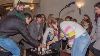 Die Gottesdienstbesucher zünden gemeinsam kleinere und größere Kerzen an, die die Wünsche der Gläubigen der Gemeinde symbolisieren.