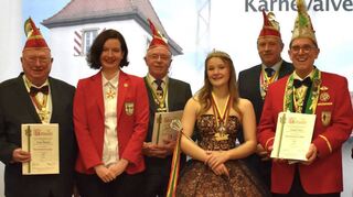 Die Senatoren der Narrhalla Ketsch Franz Becker (v. l.), Michael Seitz, Helmut Keller und Brigitte Keilbach (mit Urkunden) posieren als neue Löwenträger, während Samantha Josefine Gbur beim Showtanzeinsatz ist.