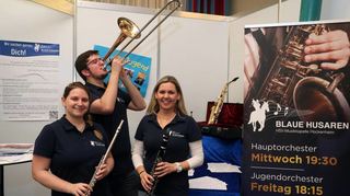 Bei der HSV-Musikkapelle „Blaue Husaren“ ist Musik drin: Ann Sophie Koppisch (v.l.), Sven Zahn und Sarah Wolf präsentieren an ihrem Stand auch Instrumente.