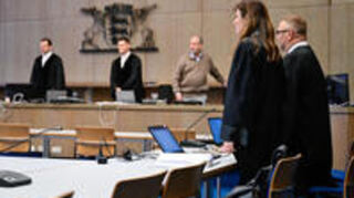 Jörg Becker und Sandra Bauer, die Rechtsanwälte der beiden Angeklagten, stehen bei Prozessbeginn bei Einzug des Gerichts im Verhandlungssaal des Landgerichts.