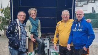 Ralf Link (v. l.), Marianne Faulhaber, Dieter Rey und Johann Becker verladen die Banankartons mit den Kerzenresten.