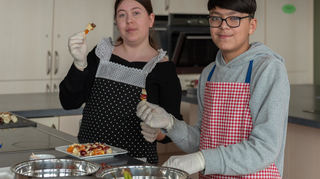 Lina und Mohammad bereiten leckere in der Marion-Dönhoff-Realschule Obstspießchen in der Küche vor