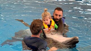 Sophia bei der Therapie mit einem Delfin.