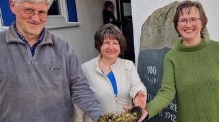 Klaus Triebskorn /l.) präsentierte Birgit Sehls und Anke Gleisner einen mit Frühlingsblumen bewachsenen Schuh, den er gefunden hatte.