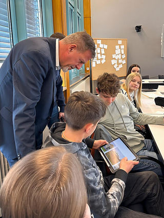 Ein Schüler zeigt dem Oberbürgermeister ein Bild eines Calisthenics-Parks.