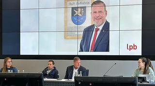 Anna-Katharina Hemer (l.) und Louisa Beisel (r.) von der Landeszentrale für politische Bildung rahmen Marcus Zeitler (zweiter von r.) und seinen persönlichen Referenten Christoph Henninger ein.