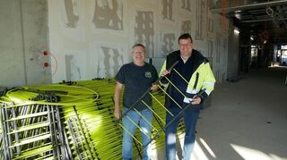 Bürgermeister Nils Drescher (r.) und Ingenieur Dietmar Defièbre mit einem kleinen Teil der Leitungen für die Fußbodenheizung, die gerade auf tausenden Metern in der großen Sporthalle eingebaut werden.