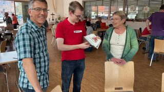 Ralf Diehlschneider und Noah helfen einer Kundin weiter.