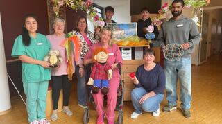 Im Caritas Altenzentrum berichten Mitarbeiter, warum sie in der Pflege arbeiten: Yasmina Karamani (v.l.), Bewohnerin Renate Schmidt, Heimleiterin Martha Trautwein, Simone Herold, Tetjana Smutok, Robin Peter. Hinter dem Snozzel-Wagen stehen die beiden ehemaligen Praktikanten Jakob-Ridderbusch (l.) und Malik Ben Ali.