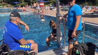 Bäderleiter Patrick Berndt (r.) und Behindertenbeauftragter Rudi Bamberger (l.) stehen zwar dabei, doch Rollstuhlfahrerin Dunja Reichert meistert den Einstieg ins Schwimmerbecken im Freibad Brühl dank des Lifts ohne jede Hilfe.