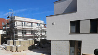 Das Mehrfamilienhaus (l.) und das Einfamilienhaus im hinteren Teil des Gelände sind am weitesten fortgeschritten im Ausbau.