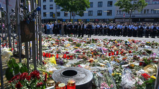 Blumen und Kerzen liegen bei einer Gedenkminute auf dem Marktplatz in Mannheim zum Gedenken an den getöteten Polizisten Rouven Laur.