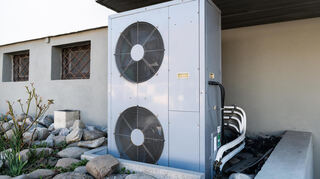 Die Lüftungsanlage einer Wärmepumpe steht vor einem Wohnhaus (Symbolbild)