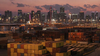Vor der Skyline der Innenstadt von Miami stapeln sich Schiffscontainer im Hafen. Deutsche Unternehmen fürchten sich vor höheren US-Zöllen.