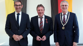 Von Staatssekretär Dr. Andre Baumann (v.l.) hat Dieter Hoffstätter das Bundesverdienstkreuz erhalten. Mit dabei bei der Verleihung: Altlußheims Bürgermeister Uwe Grempels.