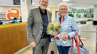 Blumen für die erste Badbesucherin 2025: Oberbürgermeister Marcus Zeitler überrascht Ilse Keller mit dem Strauß. Sie ist eine der fleißigsten Schwimmgäste des Aquadroms und freut sich, endlich wieder ins Wasser zu können.