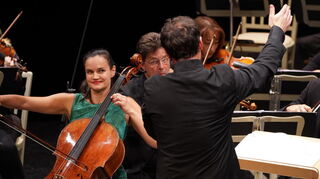 Cellistin Raphaela Gromes und Dirigent Matthew Hall (von hinten) bestimmen den Klang bei der SWR Orchesterakademie wesentlich.