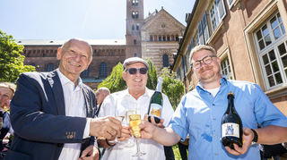 Der Dombauverein Speyer stellt im Garten nördlich des Bauwerkes den Domsekt des Winzerverein Deidesheim vor: Vorsitzender Dr. Gottfried Jung (v. l.), Etikettgestalter Oliver Schollenberger und Stefan Roos (2. Vorsitzender des Winzervereins).